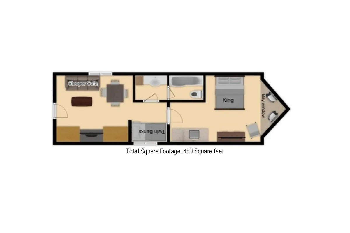 A versatile interior featuring a king bed, a sleeper sofa, and a dining table, all arranged to foster both relaxation and socializing. The sleeper sofa is prominently positioned, emphasizing its role as a central gathering spot.